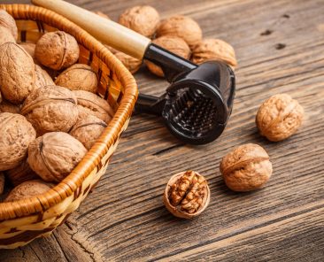 Whole and chopped walnuts on old wooden table